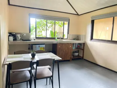 a kitchen with a table and chairs and a window at Estudio Jaguar 2 o piso Casa Jaguar in Tortuguero
