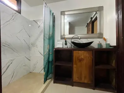a bathroom with a sink and a mirror at Estudio Jaguar 2 o piso Casa Jaguar in Tortuguero