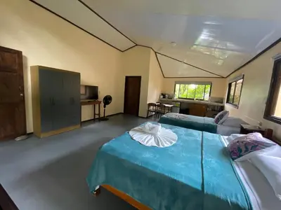a large room with two beds and a kitchen at Estudio Jaguar 2 o piso Casa Jaguar in Tortuguero