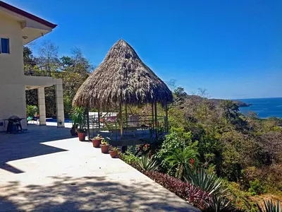 a gazebo with a straw roof on a house at Modern 4 Bedroom Infinity Pool Beach, Sunset, in Playa Hermosa