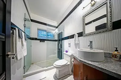 a bathroom with a sink and a toilet and a shower at Modern 4 Bedroom Infinity Pool Beach, Sunset, in Playa Hermosa