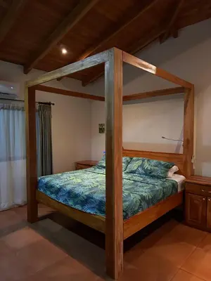 a bed in a room with a wooden bed frame at Casa Veranera in Playa Grande