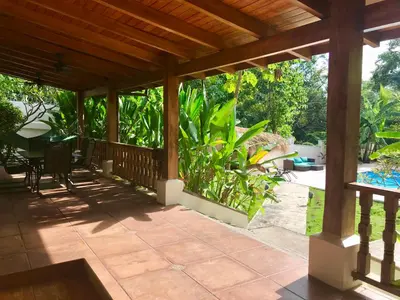 a covered porch with a table and chairs on it at Casa Veranera in Playa Grande