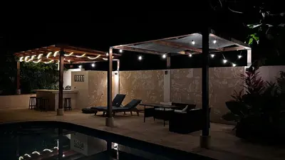 a patio at night with a table and chairs at Casa Veranera in Playa Grande