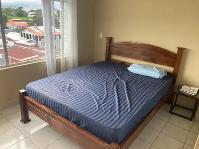 a bed sitting in a bedroom next to a window at 2 BR Condo near San Jose, Costa Rica in Santa Cruz