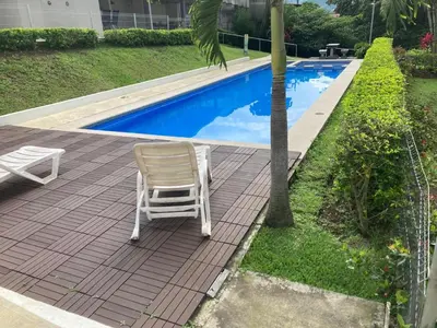 a chair sitting on a patio next to a swimming pool at 2 BR Condo near San Jose, Costa Rica in Santa Cruz