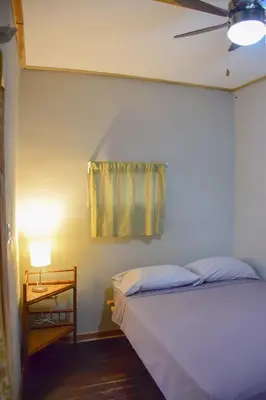 a bedroom with a bed and a table with a lamp at Noni Garden in Tamarindo