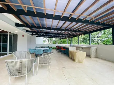 a patio with chairs and tables and a wooden ceiling at Premium Apartment In Be Cariari in Heredia
