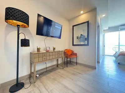 a room with a desk with a television and a lamp at Premium Apartment In Be Cariari in Heredia