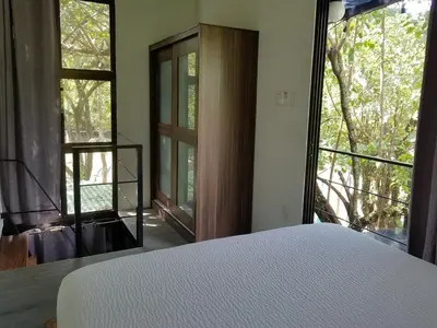 a bedroom with a bed and a large window at El Congo Apartmento in Nicoya
