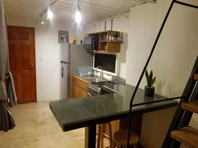 a kitchen with a counter top and a refrigerator at El Congo Apartmento in Nicoya