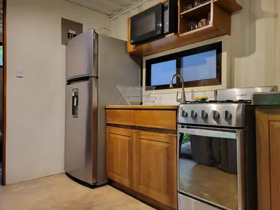 a kitchen with a stainless steel refrigerator and a sink at El Congo Apartmento in Nicoya