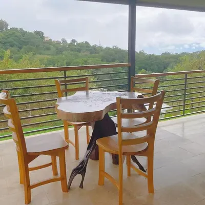 a table and chairs on a balcony with a view at Casa Brisa house in the mountains 15 minutes from the beach in Nicoya