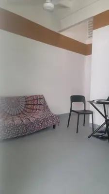 a room with a bed and a chair and a table at Residencial Oasis in Sámara