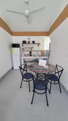 a room with a table and chairs and a kitchen at Residencial Oasis in Sámara