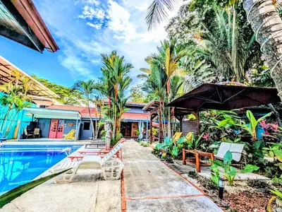 a resort with a swimming pool and palm trees at Intimate Earthy Vibe - Bedroom in a Tropical Paradise in Herradura