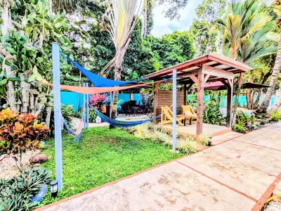 a hammock in a garden with a gazebo at Lovely Tropical Ensuite Bedroom - Pool AC Hot Water in Herradura
