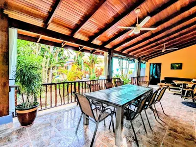 a dining room with a table and chairs on a balcony at Lovely Tropical Ensuite Bedroom - Pool AC Hot Water in Herradura