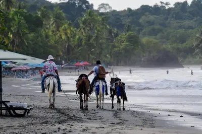 a group of people riding horses on the beach at Lovely Tropical Ensuite Bedroom - Pool AC Hot Water in Herradura