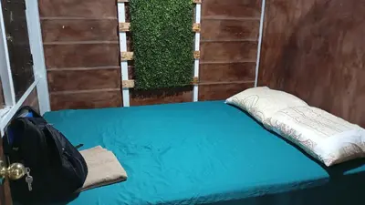 a bed with a pillow and a backpack on it at Cabaña Renaciendo in Turrialba