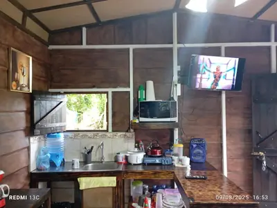 a kitchen with a sink and a tv on the wall at Cabaña Renaciendo in Turrialba