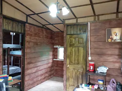 a room with wooden walls and a door in a room at Cabaña Renaciendo in Turrialba