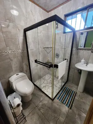 a bathroom with a shower and a toilet and a sink at La Fortuna, Fluca House 2 in Fortuna