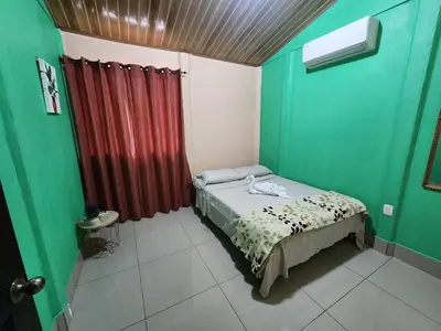 a small bedroom with green walls and a bed in it at La Fortuna, Fluca House 3 in Fortuna