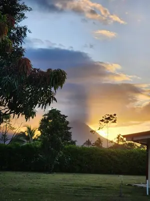 a sunset over a field with trees in the foreground at La Fortuna, Fluca House 3 in Fortuna