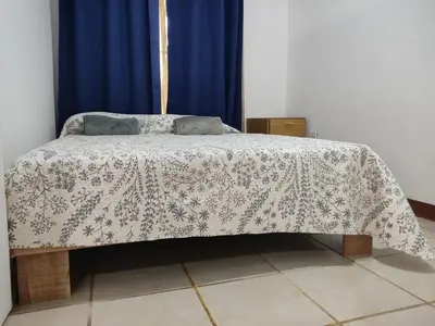 a bed in a room with a blanket on it at Hostel Cora Chia in Pedregal