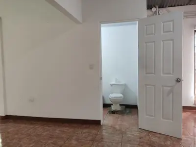 a bathroom with a white door and a toilet at Hostel Cora Chia in Pedregal