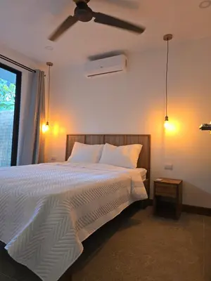 a bedroom with a white bed with a ceiling fan at Villa del pájaro pecho amarillo in Fortuna