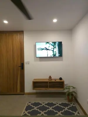a living room with a television on a wall at Villa del pájaro pecho amarillo in Fortuna