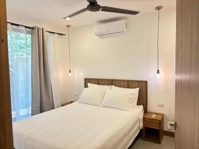 a bedroom with a bed with a ceiling fan at Villa del pájaro pecho amarillo in Fortuna