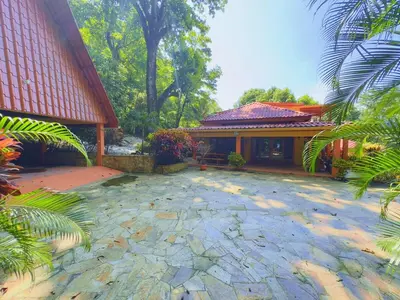 a house with a stone patio in front of it at Casa Mariposa cozy house 5 minutes from the beach in Sámara