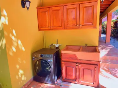 a washing machine and a sink in a room at Casa Mariposa cozy house 5 minutes from the beach in Sámara