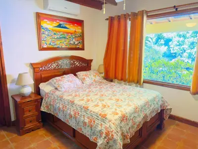 a bedroom with a bed and a window at Casa Mariposa cozy house 5 minutes from the beach in Sámara