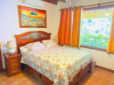 a bedroom with a bed and a window at Casa Mariposa cozy house 5 minutes from the beach in Sámara