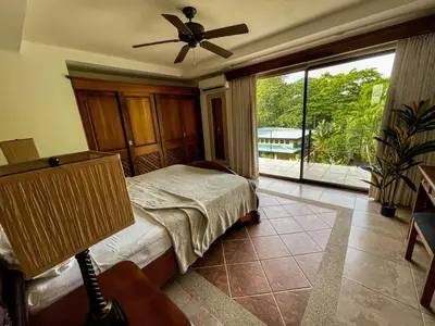 a bedroom with a bed and a ceiling fan at Beachfront Balcony Sunset 2B in Jacó