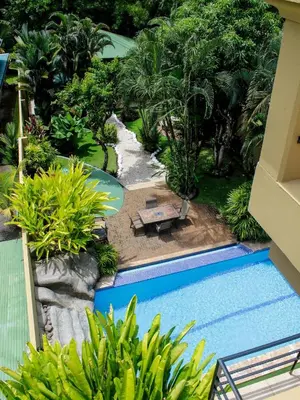a view of a garden with a swimming pool at Beachfront Balcony Sunset 2B in Jacó