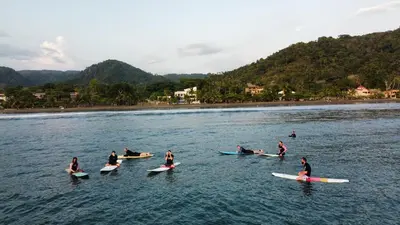 a group of people on surfboards in the water at Beachfront Balcony Sunset 2B in Jacó