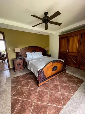 a bedroom with a large bed with a ceiling fan at Beachfront Balcony Sunset 2B in Jacó