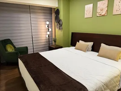 a bedroom with a large bed and a chair at Penthouse San José Costa Rica in San José