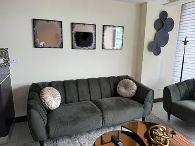 a living room with a green couch and a table at Penthouse San José Costa Rica in San José