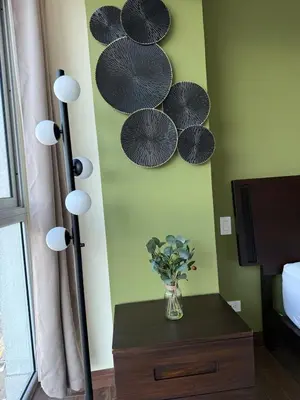 a room with a lamp and a vase of flowers on a table at Penthouse San José Costa Rica in San José