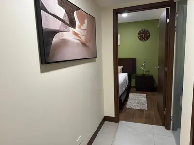 a hallway with a painting hanging on a wall at Penthouse San José Costa Rica in San José