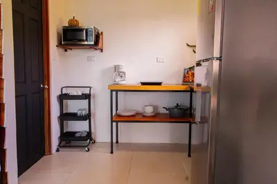 a small kitchen with a table and a microwave at Monte y Alma Monteverde in Cebadilla