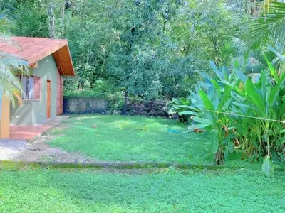 a yard with a house and a garden with green grass at Casa Redonda Tranquil House 15 Minutes from Samara by Car in Nicoya