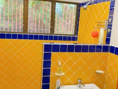 a yellow and blue tiled bathroom with a sink at Casa Redonda Tranquil House 15 Minutes from Samara by Car in Nicoya