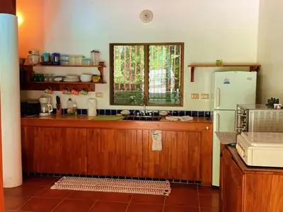 a kitchen with a refrigerator and a window at Casa Redonda Tranquil House 15 Minutes from Samara by Car in Nicoya